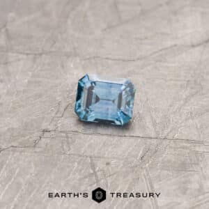 A blue-green Montana sapphire in a classic emerald cut