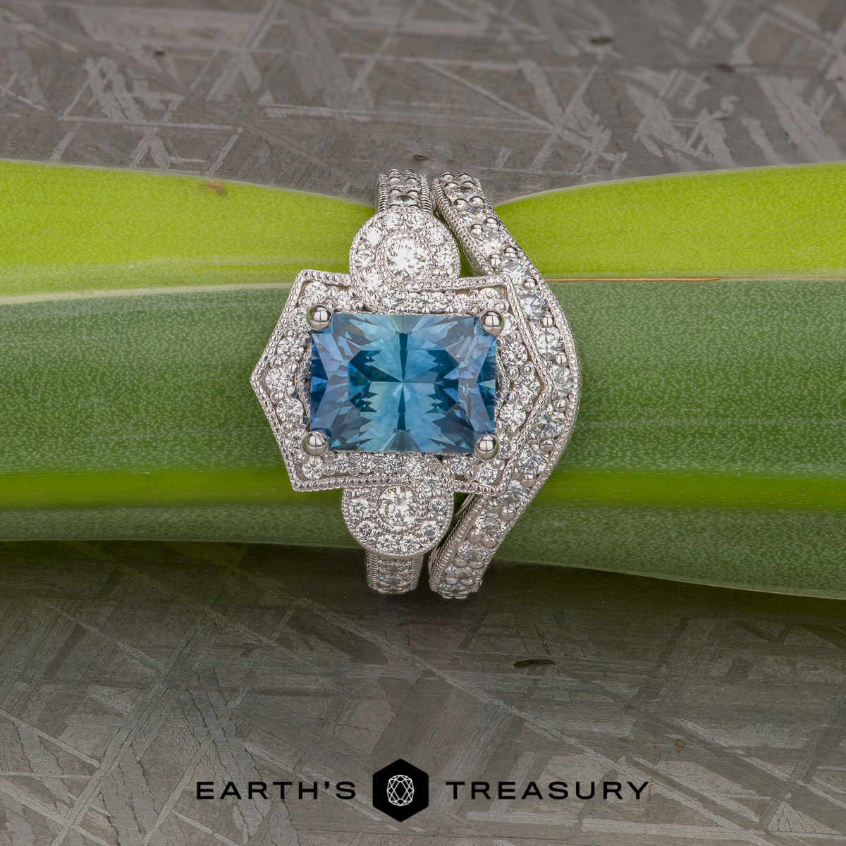 A studio shot featuring a custom vintage-inspired ring set with a large rectangular Montana sapphire