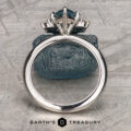 The Stacked from 55 images. Method=B (R=1,S=1) ring with a large blue gemstone is displayed upright against a rough blue stone on a textured gray surface, with the Earth’s Treasury logo at the bottom.