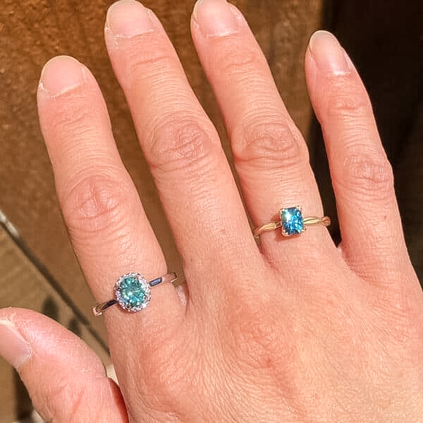 A photo from a customer review featuring two rings. On the left, an "Alice" ring in 14k white gold with 0.96-Carat Montana Sapphire. On the right, a ring not made by Earth's Treasury with a 0.88-Carat Montana Sapphire.