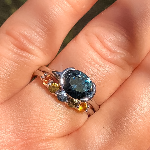 A custom ring in platinum with a 2.59-carat Montana sapphire alongside a custom sapphire band