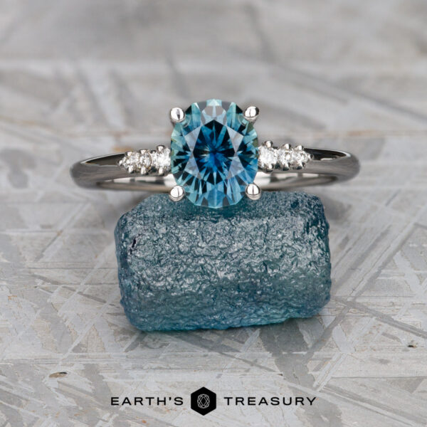 The "Paloma" ring in 18K white gold with 1.51-carat Montana sapphire The "Paloma" ring in 18K white gold, featuring a 1.51-carat Montana sapphire and diamond accents, is displayed balanced on a rough blue stone with the Earth’s Treasury logo below.