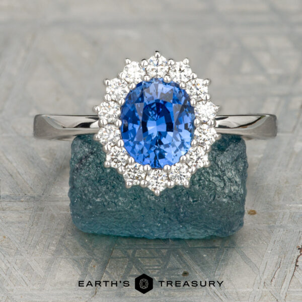 The "Vivian" ring in 18K white gold with 1.59-carat Ceylon sapphire The "Vivian" ring in 18K white gold features a 1.59-carat Ceylon sapphire surrounded by sparkling stones, displayed on rough blue crystal with “Earth’s Treasury” text—a standout from the Vivian collection.