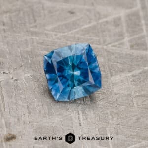 A blue-green Montana sapphire in our "Aurora" square cushion design
