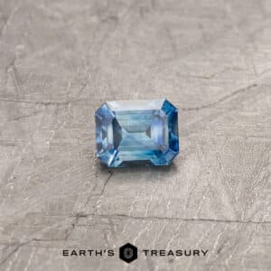 A blue-green Montana sapphire in a classic emerald cut