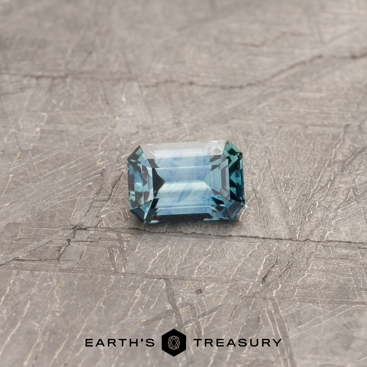 A blue-green Montana sapphire in a classic emerald cut