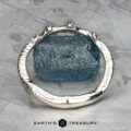 The "Juniper" band in platinum, featuring a textured design with blue gemstones, rests elegantly on a rough blue stone surface, set against a soft gray background evocative of the soothing notes of music.