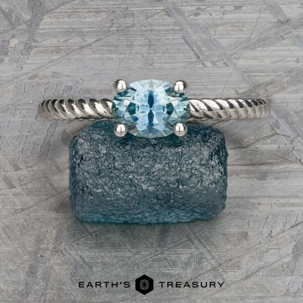The "Winnie" ring in platinum with 0.95-carat Montana sapphire The "Winnie" ring in platinum, featuring a captivating 0.95-carat Montana sapphire, elegantly rests on a rough blue stone background, capturing the essence of Winnie’s timeless style.