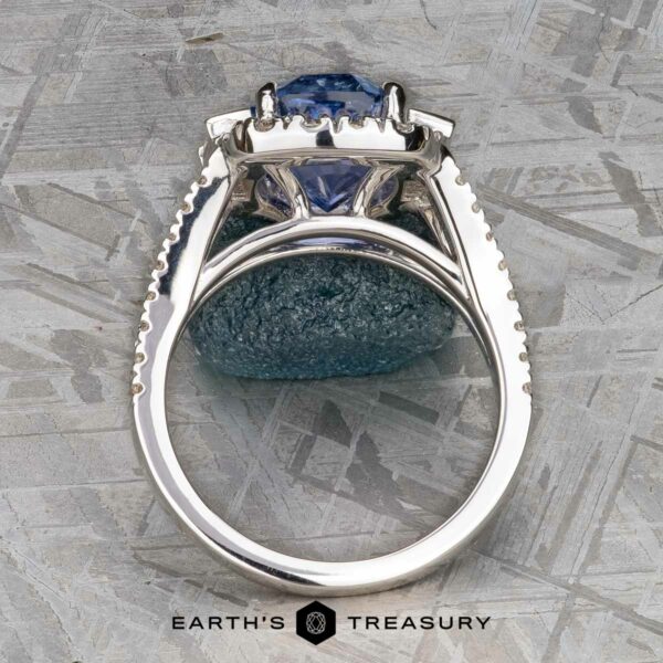 Vintage Halo Ring with 5.09-Carat Ceylon Sapphire in 18k white g This exquisite vintage halo ring features a stunning 5.09-carat Ceylon Sapphire set in prongs, beautifully displayed on an 18k white gold textured surface. At the bottom, the logo proudly reads "Earth's Treasury.