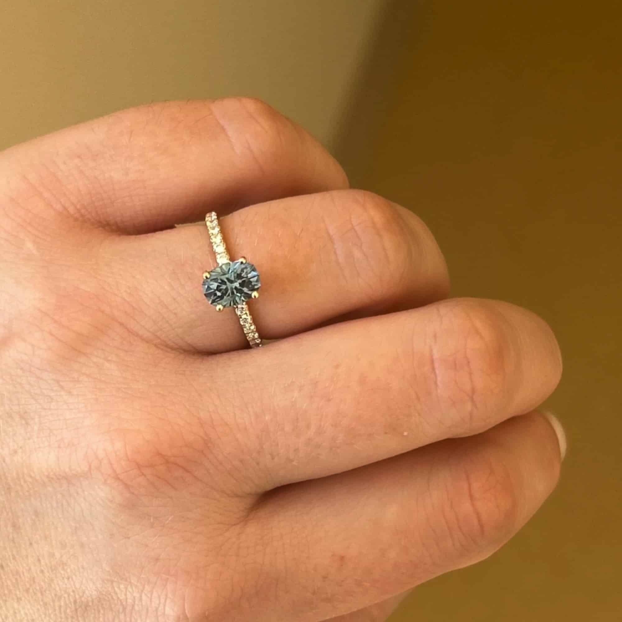 A photo from a customer review featuring a petite pave "Eugenie" ring in 14k yellow gold with a 1.52-carat Montana sapphire