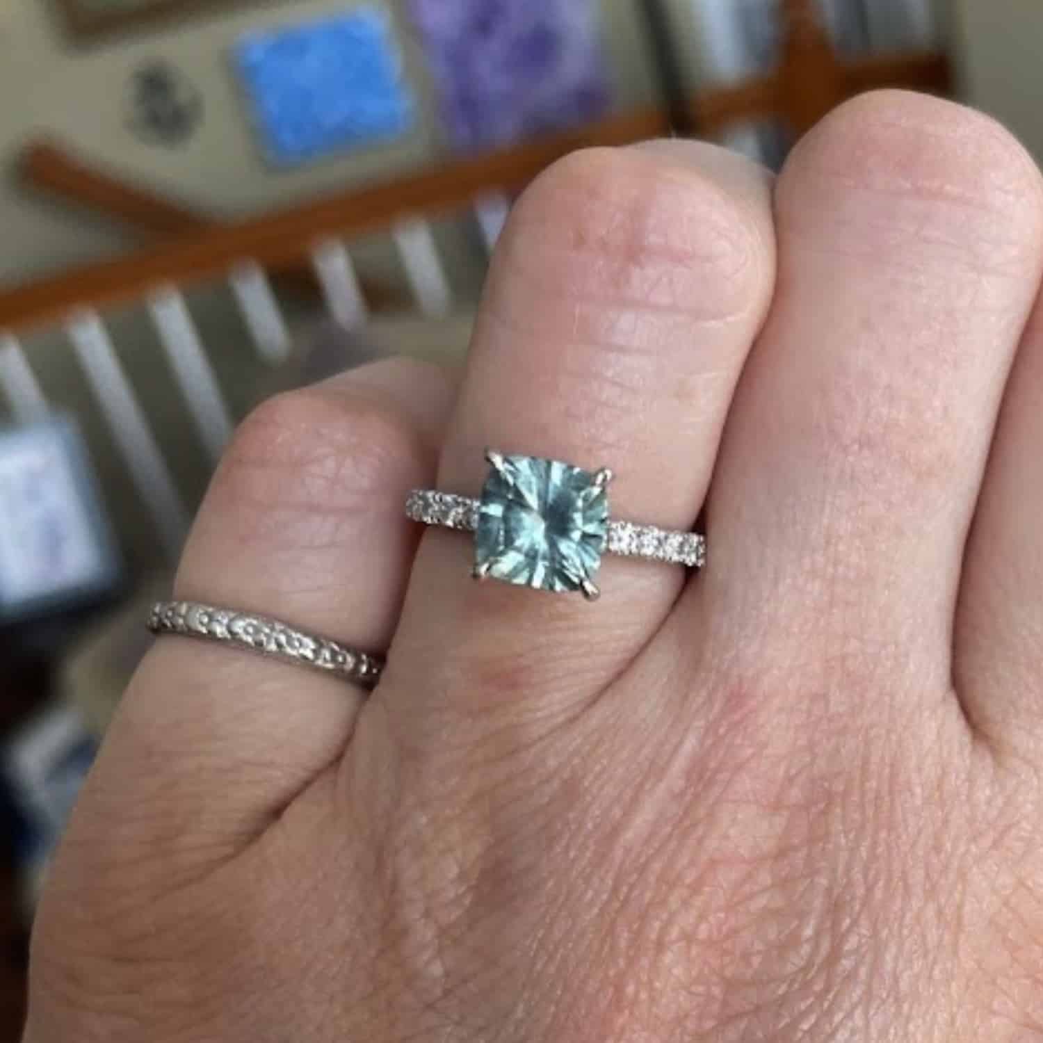 A photo from a customer review featuring a the "Madeline" pave ring with an icy blue square sapphire
