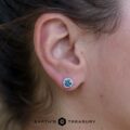 A photo on an ear of 5.0mm hexagon halo Montana sapphire earrings
