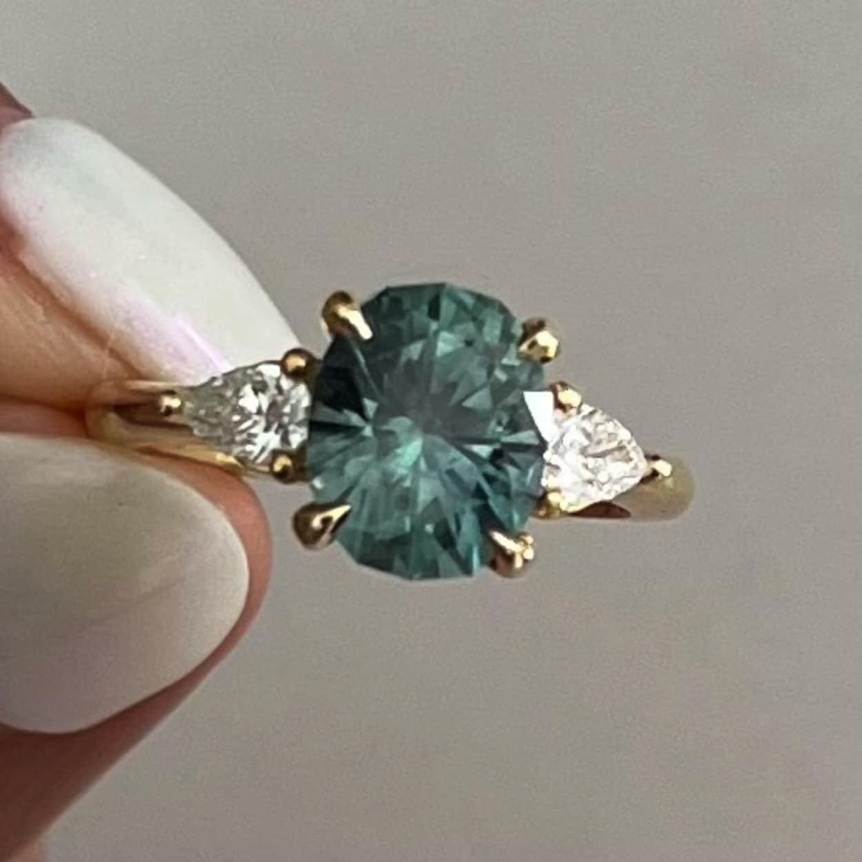 A photo from a customer review, featuring a ring not made by Earth's Treasury including a 2.30-Carat Spruce Green Montana Sapphire