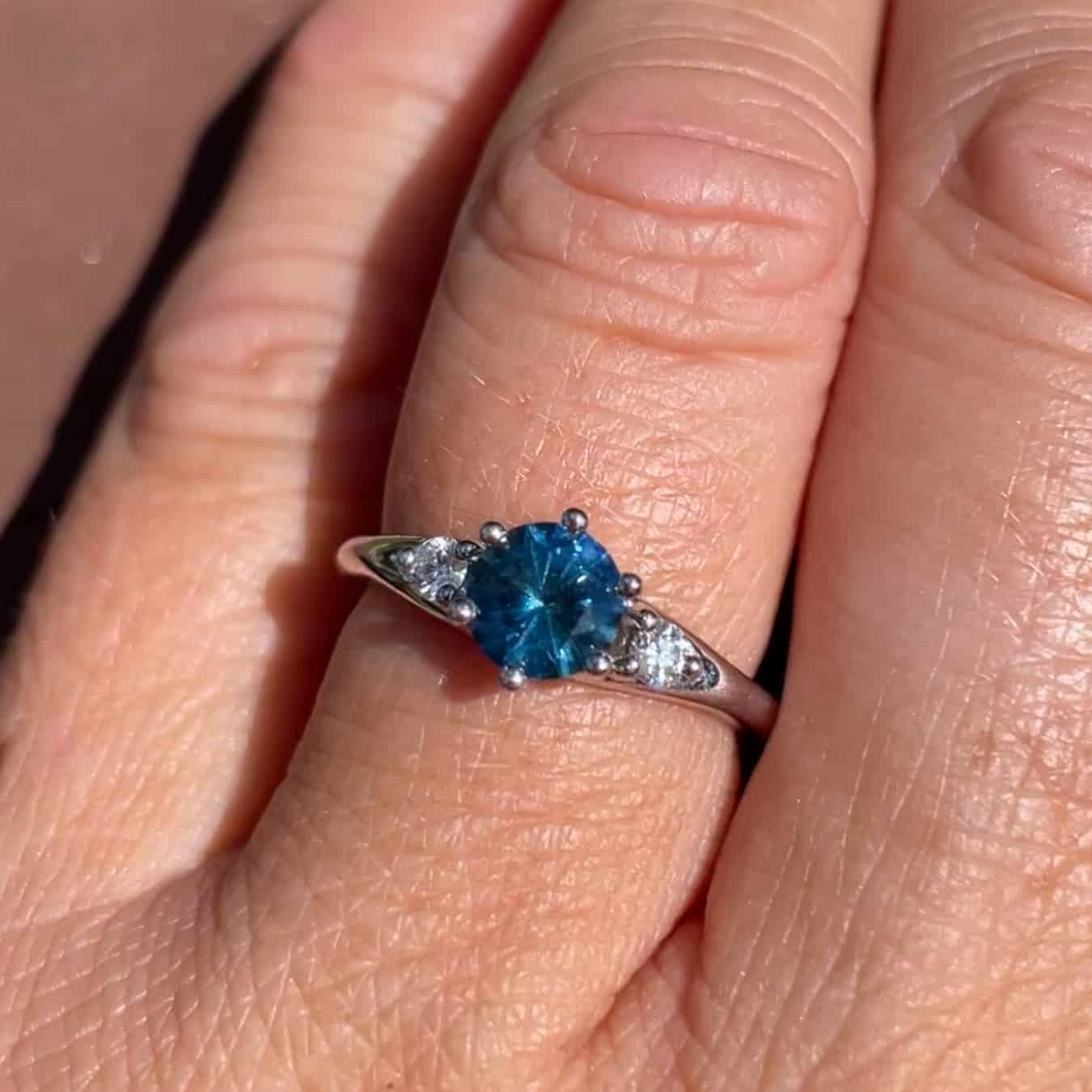A photo from a customer review featuring a white gold "Halley" ring with a round teal Montana sapphire