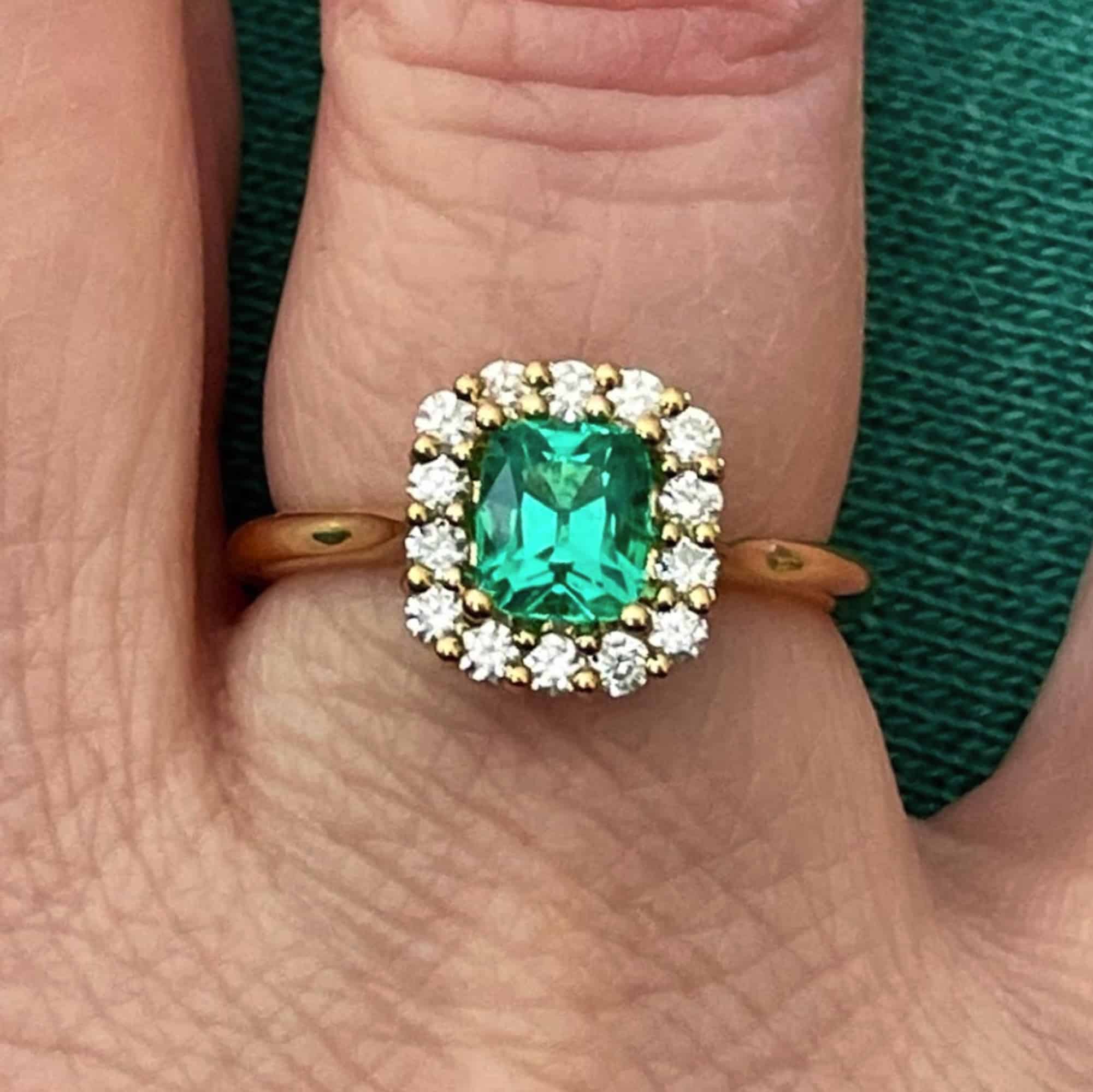 A photo from a customer review showing a yellow gold halo ring with rectangular emerald