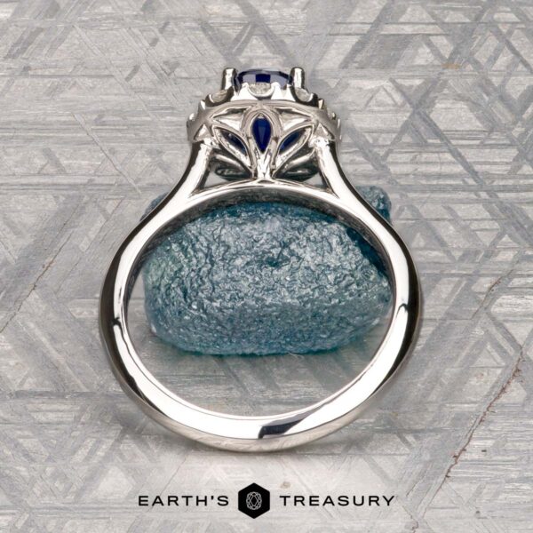 The Pave "Valeria" ring in platinum with 1.41-carat Ceylon sapphire The Pave "Valeria" ring in platinum features a 1.41-carat Ceylon sapphire and pave-set diamonds, shown on a rough blue stone with engraved patterns in the background.