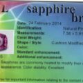 An identification card from AGL for a 1.71-Carat Hot Pink Ceylon Sapphire (Heated) includes details such as the date (24 February 2014), stone's measurements (7.58 x 5.91 x 4.20 mm), shape and style (cushion modified mixed cut), color (pink), and enhancement method (heat).