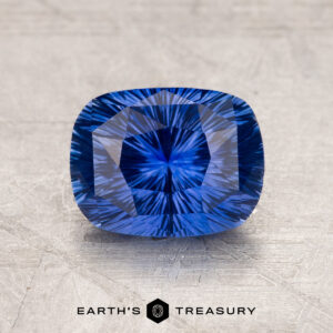 A close-up image of a 1.97-carat Ceylon Sapphire with intricate internal patterns, set against a textured gray background. Text at the bottom reads "EARTH'S TREASURY.