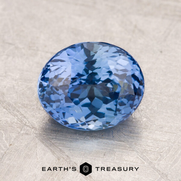 Close-up image of a faceted oval-blue 2.34-Carat Sapphire displayed on a textured surface, with the text "Earth's Treasury" below it.