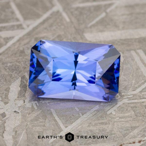 2.08-Carat Medium Blue Tanzanite (Heated) A 2.08-carat medium blue tanzanite with intricate facets, set against a textured gray background. The text "Earth's Treasury" appears at the bottom.