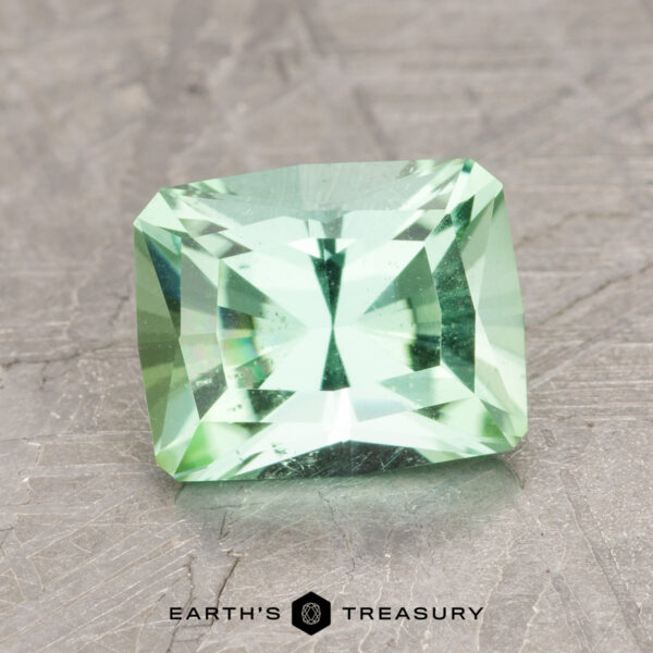 1.91-Carat Mint Green Tourmaline An image labeled "Earth's Treasury" showcases product ET1412, a radiant-cut, light green rectangular gemstone resting on a textured gray surface.