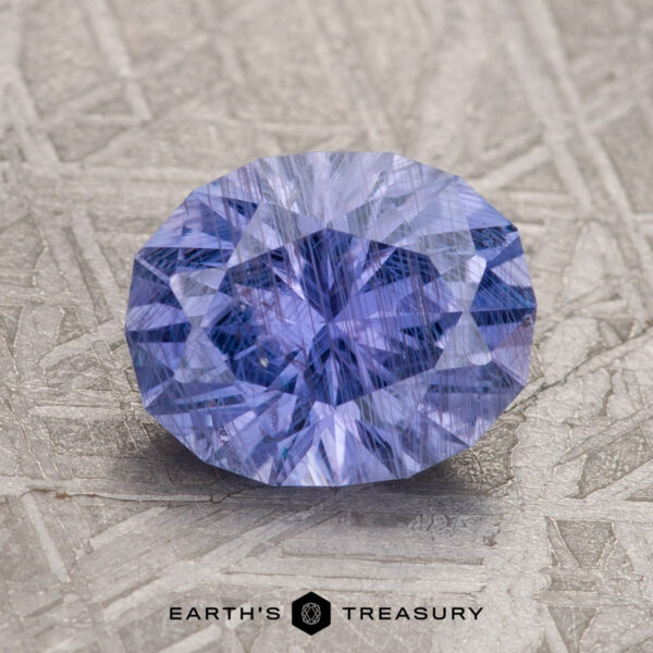 2.31-Carat Violet Umba Sapphire A 2.31-carat Violet Umba Sapphire is showcased on a textured surface with the text "Earth's Treasury" below it.