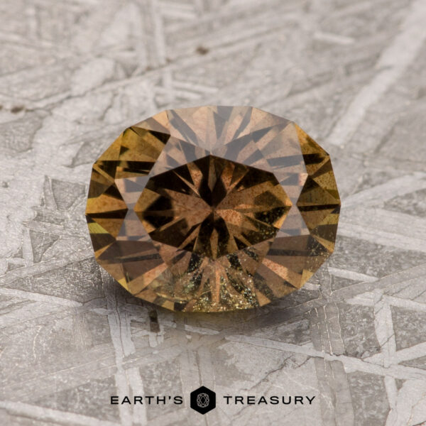 2.20-Carat Warm Brown Umba Sapphire A 2.20-carat warm brown Umba Sapphire is displayed against a textured background. The image text reads "Earth's Treasury.