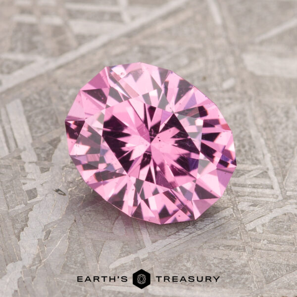 2.02-Carat Bubblegum Pink Mahenge Garnet A 2.02-carat Bubblegum Pink Mahenge Garnet displayed on a textured surface with the logo and text "Earth's Treasury" below.