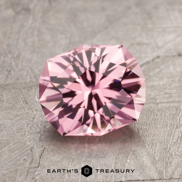 1.77-Carat Pink Tourmaline A faceted pink gemstone named ET1609 is displayed on a gray textured background, with the text "Earth's Treasury" elegantly inscribed.