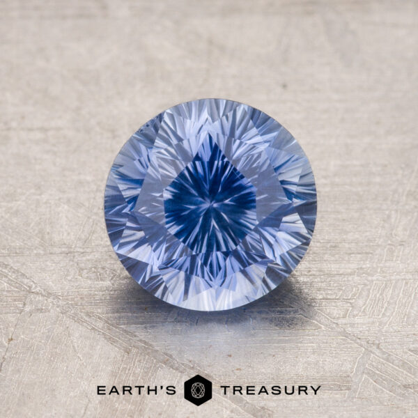 1.99-Carat Ceylon Sapphire A close-up image of a round brilliant-cut blue gemstone on a textured surface with the text "1.99-Carat Ceylon Sapphire" at the bottom.