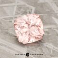 A 1.84-carat pink-peach pastel pyrope garnet is showcased on a textured gray surface, with the text "Earth's Treasury" at the bottom.