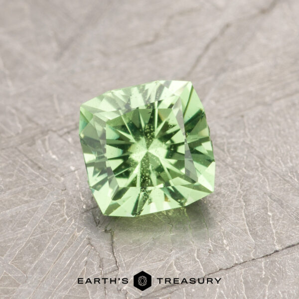 0.94-Carat Mint Green Grossular Garnet Introducing ET1108: A stunning square-cut green gemstone with precise facets, elegantly displayed on a textured gray surface.