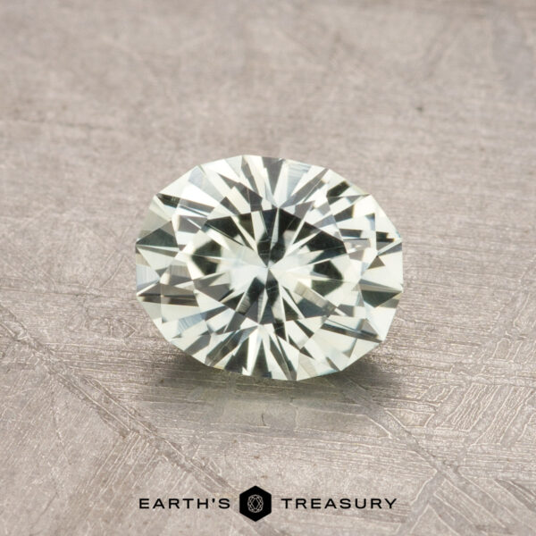 1.09-Carat Montana Sapphire (Heated) The 1.09-carat Montana sapphire (heated), cut in an oval shape, is displayed on a textured surface.
