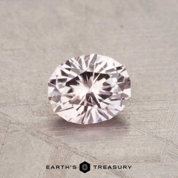 0.79-Carat Montana Sapphire (Heated) A 0.79-carat faceted oval Montana sapphire with a sparkling appearance on a textured surface.