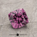 The ET1993, a square-cut purple gemstone with intricate facets, is elegantly displayed on a textured gray surface.