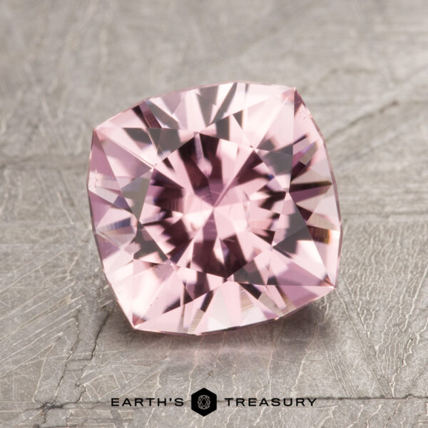1.98-Carat Pink Tourmaline A square-cut pink gemstone with intricate facets, displayed on a textured gray surface, is paired with the text "Earth's Treasury," accompanied by the model identifier "ET1600" at the bottom.