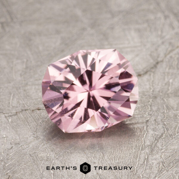 1.22-Carat Pink Tourmaline A faceted ET1620 pink gemstone rests on a textured gray surface.