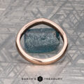 The "Ramona" band in 14K rose gold rests on a rough blue stone atop a geometric silver background, with the “Earth's Treasury” logo displayed below.