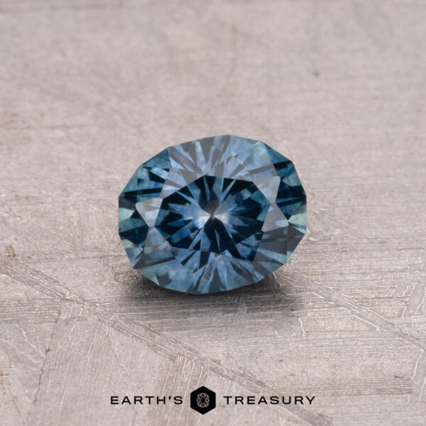 0.78-Carat Montana Sapphire (Heated) A 0.78-carat Montana sapphire, heated to perfection, is elegantly showcased on a textured surface, captioned "Earth's Treasury.