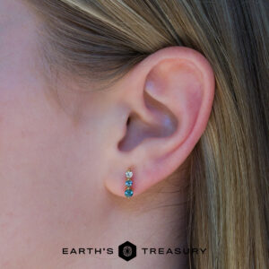 Close-up of a person’s ear wearing three vertically aligned Dawn Earrings; the "Earth’s Treasury" logo appears at the bottom.