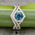 The "Graciella" ring in 14k white gold with a 1.27-carat Montana sapphire and the "Graciella" band, both in 14k white gold, are shown on a green plant stem with the "Earth's Treasury" logo below.