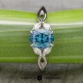 A platinum "Anise" ring featuring a 1.37-carat Montana Sapphire, marquise and round diamonds, displayed on a green striped background with the "Earth's Treasury" logo below.