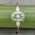 The "Dryad" ring in 14k yellow gold features a 3.50-carat oval Montana sapphire and two pear-shaped clear stones, shown on a green stem with the "Earth's Treasury" logo below.