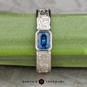 The "Kittley" ring in platinum, featuring a 0.80-carat Montana Sapphire, is displayed on a green stem with the "Earth's Treasury" logo below.