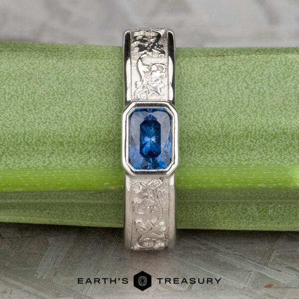 The "Kittley" ring in platinum, featuring a 0.80-carat Montana Sapphire, is displayed on a green stem with the "Earth's Treasury" logo below.