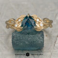 The "Viney" ring in 14K yellow gold features a 1.39-carat Montana sapphire and four small round diamonds, showcased on a textured blue stone.