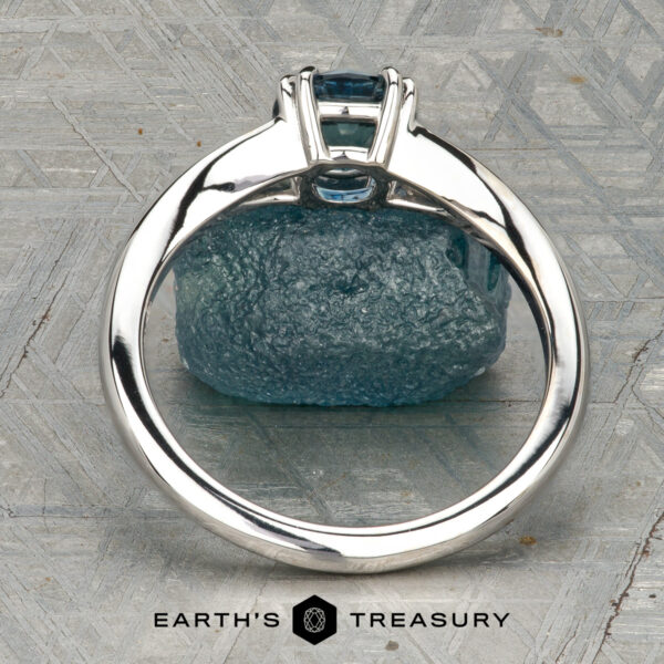 The Marlowe Ring The Marlowe Ring is shown upright before a rough blue stone on a patterned gray surface, with “EARTH'S TREASURY” displayed at the bottom.
