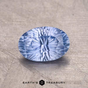 A 1.30-Carat Ceylon Sapphire, a faceted blue gem, is showcased on a textured background with the "Earth's Treasury" logo beneath.
