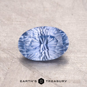 A 1.30-Carat Ceylon Sapphire, a faceted blue gem, is showcased on a textured background with the "Earth's Treasury" logo beneath.
