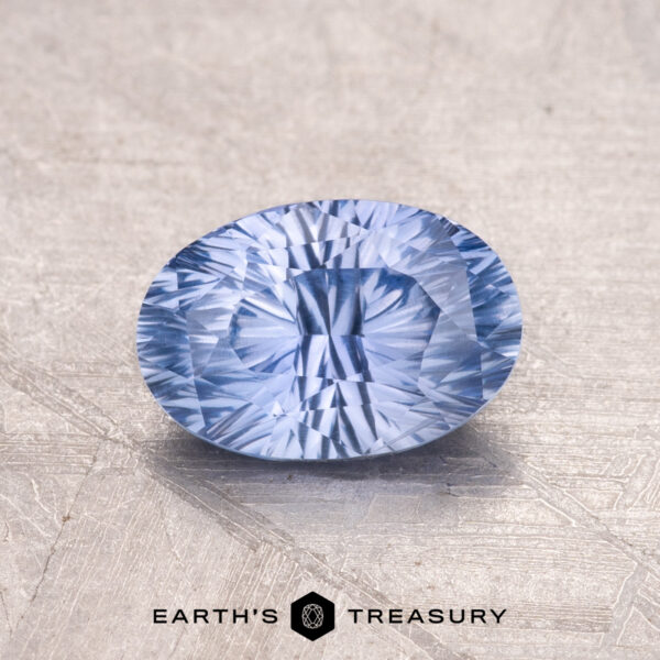 1.30-Carat Ceylon Sapphire A 1.30-Carat Ceylon Sapphire, a faceted blue gem, is showcased on a textured background with the "Earth's Treasury" logo beneath.